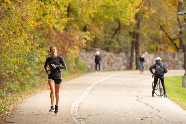 A girl runs along a path through the fall colors