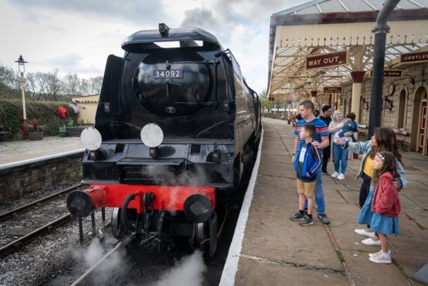 Steam train on platform with families watching