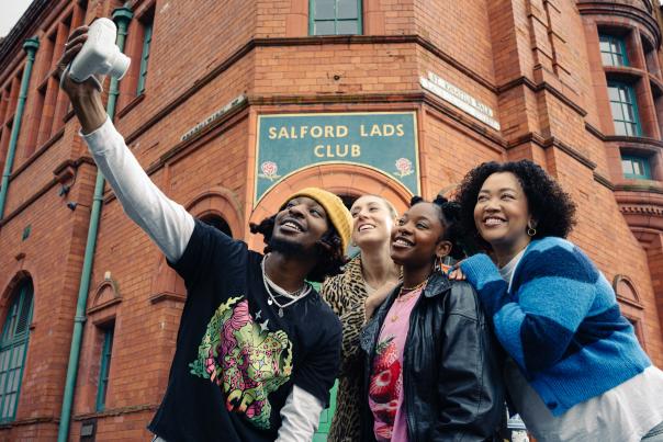 A group of friends taking a selfie outside of Salford Lads Club
