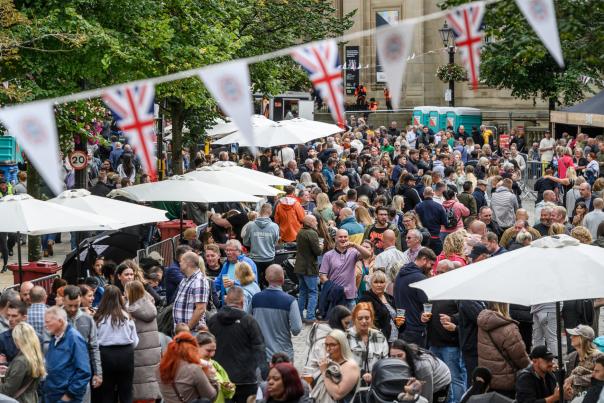 Group of people at a food and drink festival with stalls and bunting