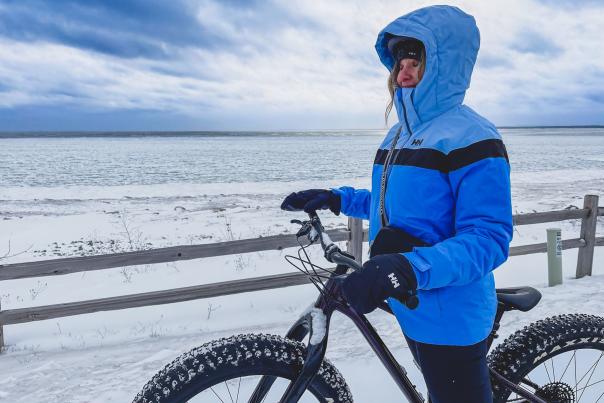 Woman standing with snow bike in front of Lake Superior