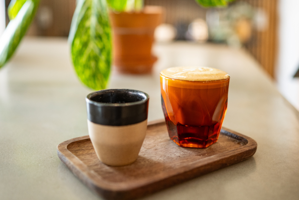 Two hot coffee lates on a wooden tray from Filtered Coffee Shop