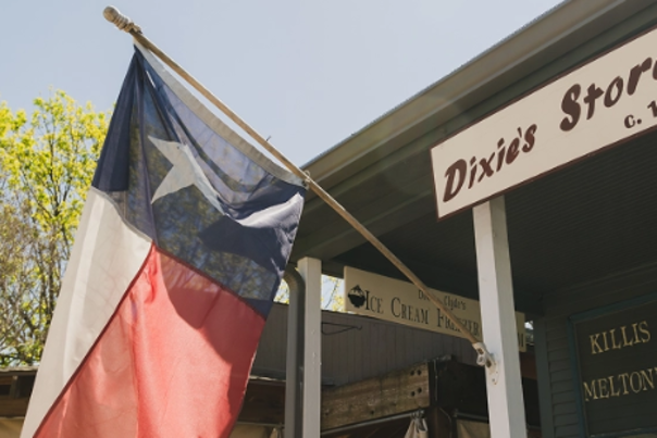 Dixie's Store with a Texas flag hanging outside the window