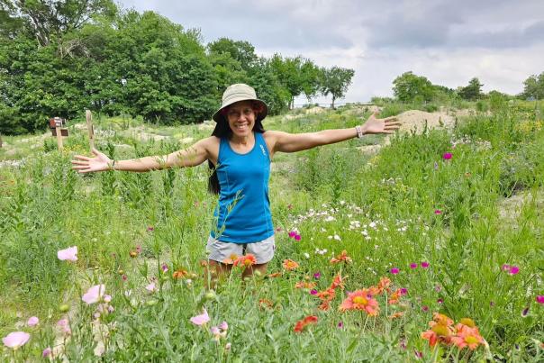 Young woman holding her arms out to her side in a flower field at The Heard Museum.