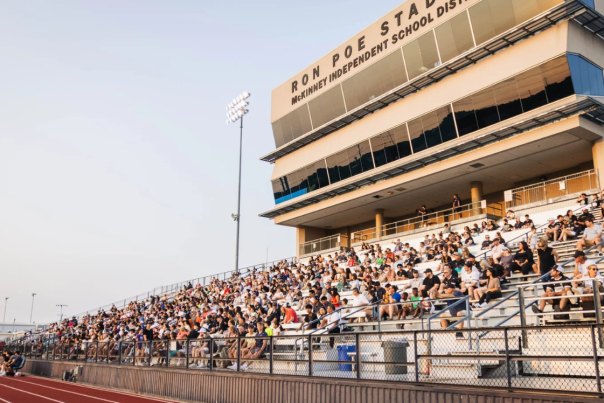 Fans in a stadium cheering on a soccer game