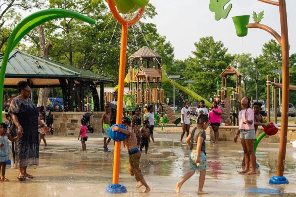 Splash pad with interactive water features and kids running around enjoying the water