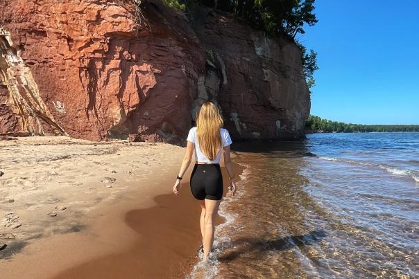 A woman walking on a Lake Superior Beach in the Upper Peninsula of Michigan