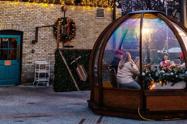 Friends enjoying a meal in an outdoor dome.