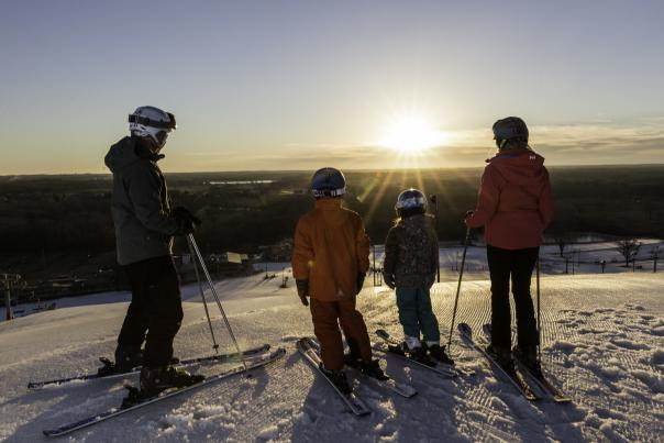 A family skiing at Wilmot during sunset in the winter
