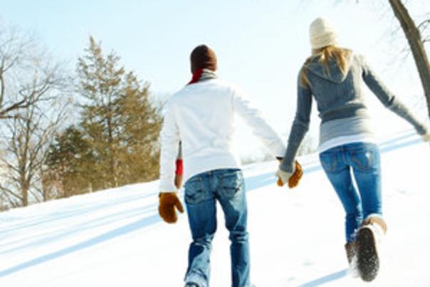 V-day couple wlaking up hill in snow
