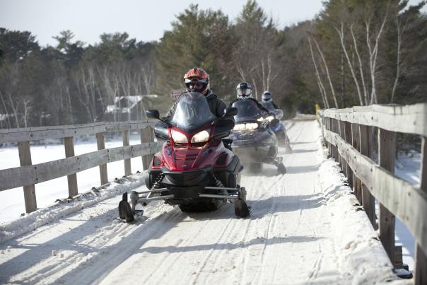 A group heads into the Minocqua wilderness on their snowmobiles.