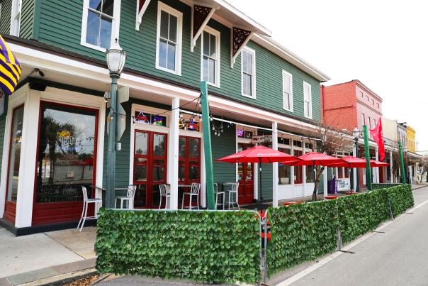 Outdoor seating: picnic tables with umbrellas and greenery