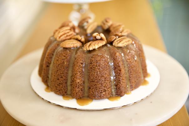 bundt cake drizzled with caramel and topped with pecans