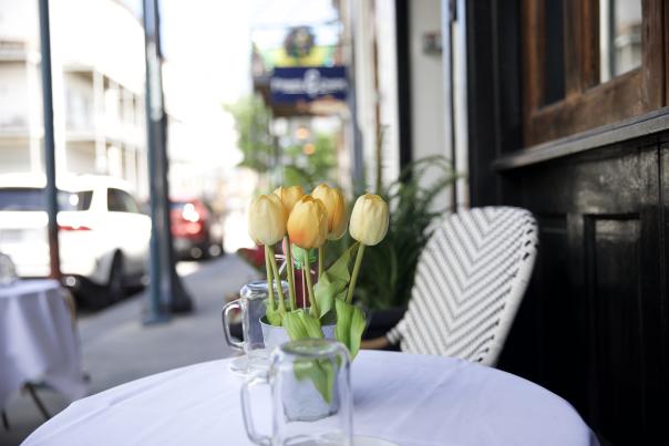 table and chair with a vase of tulips, outside dining
