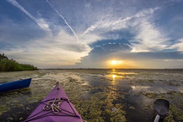 View of sunset over the water from a kayak