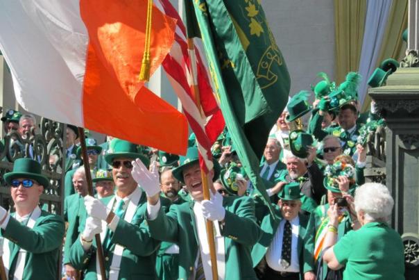 parade of people dressed in green and flying Irish flags