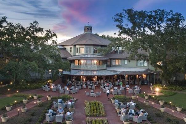 Exterior of the Grand Hotel at dusk with lit walkways and seating
