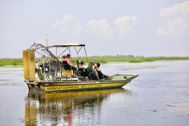 Yellow airboat with passengers in still waters
