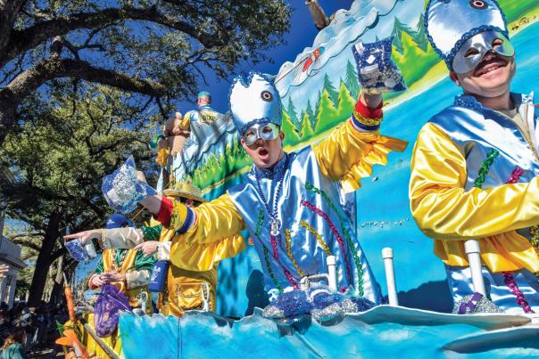 Man in Mardi Gras costume riding a Mardi Gras float