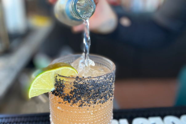 pouring a drink with lime garnish
