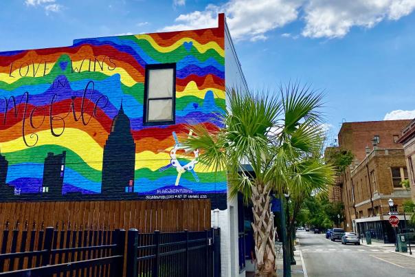 building with a mural of the city and a rainbow background