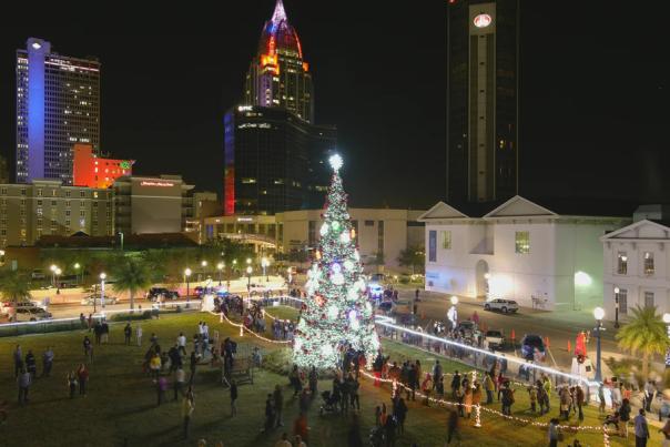 overhead view of crowd around a large Christmas tree with hi-rise buildings in the background