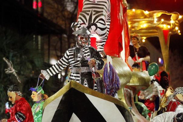 man in striped costume standing on a Mardi Gras float