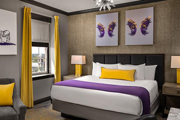 Hotel room bed, two framed artwork of wings above the bed