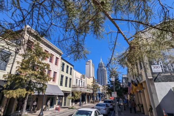 view of city street with buildings on both sides, skyscraper in the background