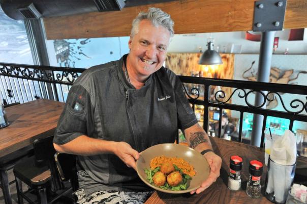 man smiling while holding a plate of food