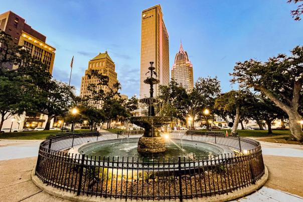 Fountain in a park with high rise buildings in the background