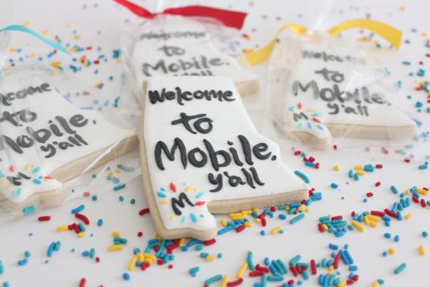 Alabama shaped cookie with icing that reads welcome to Mobile y'all