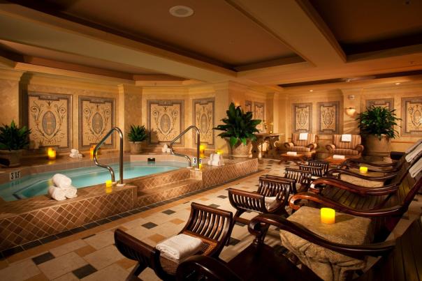 room with indoor pool and wooden chaise lounges