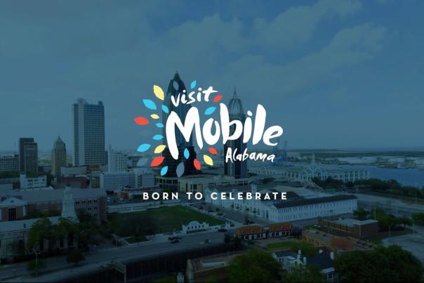 city skyline with the Visit Mobile logo