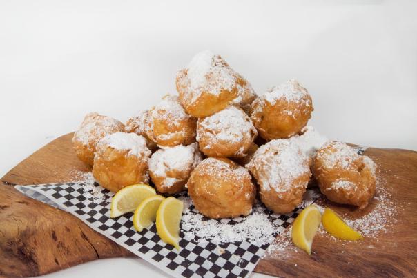 beignets with powdered sugar and lemon slices