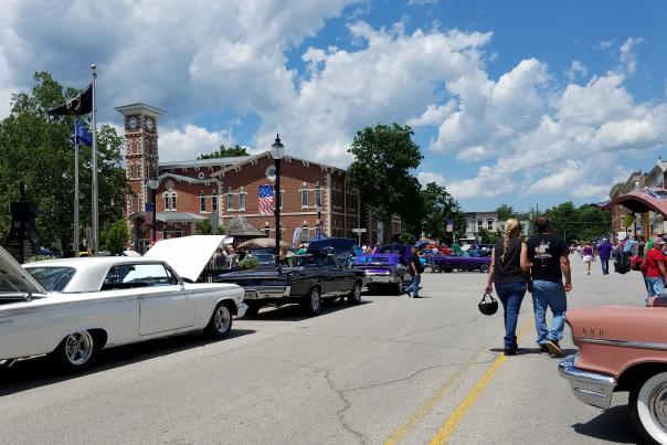 A couple strolls through downtown Martinsville, Indiana during a local car show event.