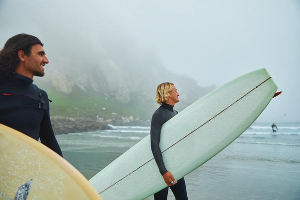 Two surfers standing in the beach