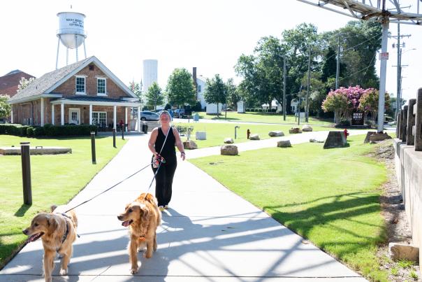 Woman walking two dogs at the Rocky Mount Mills in Rocky Mount, North Carolina