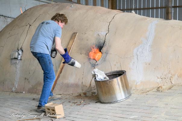Artist tending the firebox of Dan Finch's wood-fired pottery kiln in Bailey, North Carolina.