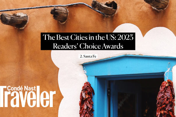 red chile ristras hang from a blue doorway, accentuated by white paint. text reads the best cities in the US: 2025 Readers' choice awards, number 2 Santa Fe