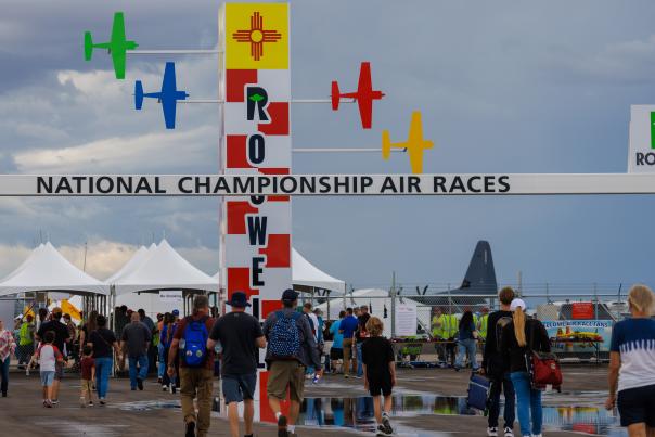 Photo of a group of attendees walking under a welcome archway for the Roswell National Championship Air Races