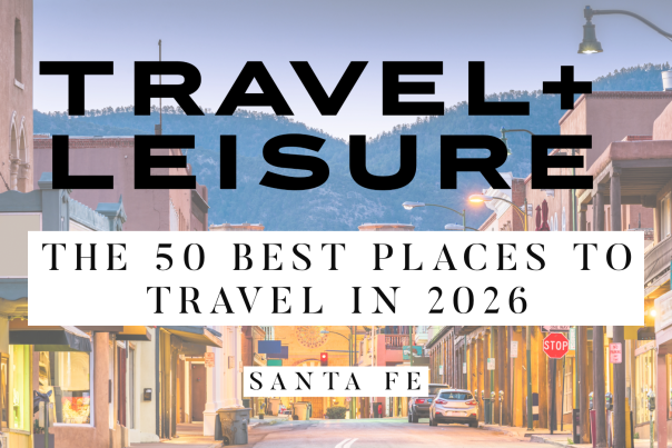 Background image of downtown Santa Fe taken at dusk with mountains in the background with overlaid text that reads, "Travel and Leisure: The 50 Best Places to Travel in 2026 - Santa Fe."