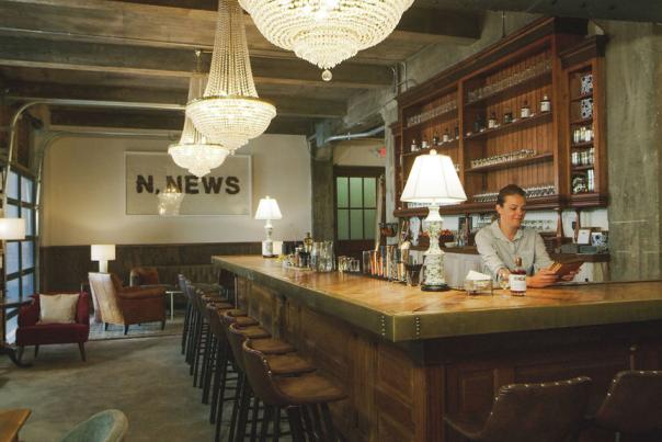 Ironclad Distillery Lobby - N. News Sign Hangs in Back with Bar and chandelier taking up most of the space