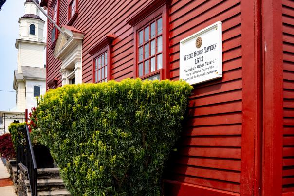 external photo of white horse tavern, a colonial era style building with red clapboards