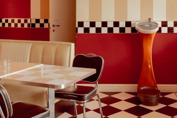 Interior of a classic American diner with retro décor including booth seating, period lighting, and vintage counter details