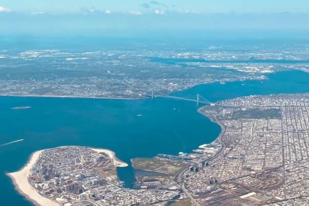 Aerial view of Coney Island beach and boardwalk in Brooklyn with the Atlantic Ocean stretching into the horizon