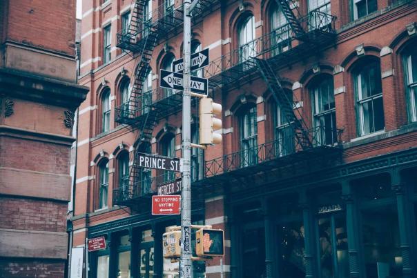 Cast-iron building facades lining a SoHo Manhattan street on a clear day