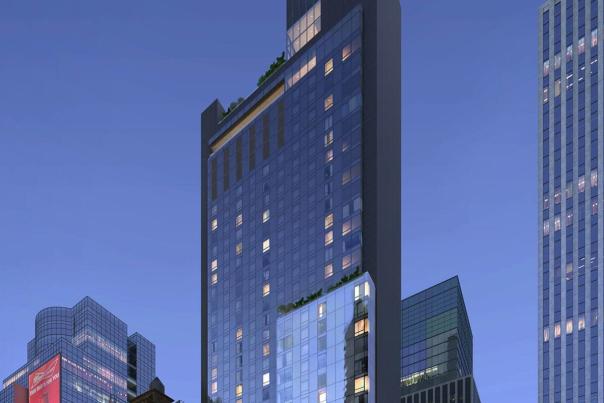 Hard Rock Hotel New York glass tower rising above Midtown Manhattan at dusk with illuminated Hard Rock logo and Times Square visible below