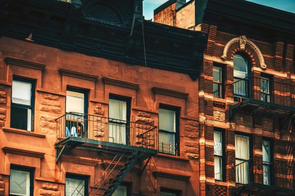 Historic New York City brownstone buildings standing tall along a preserved residential street, showing the architectural character protected by landmark laws