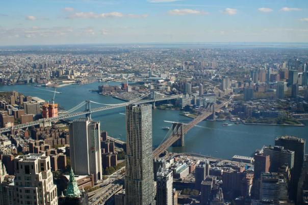 Panoramic black-and-white view of the Manhattan Bridge and New York City skyline from across the water